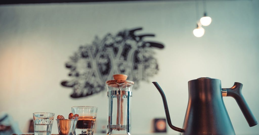 Elegant coffee arrangement with a French press, kettle, glasses, and coffee beans on a table. how to make the best coffee at home